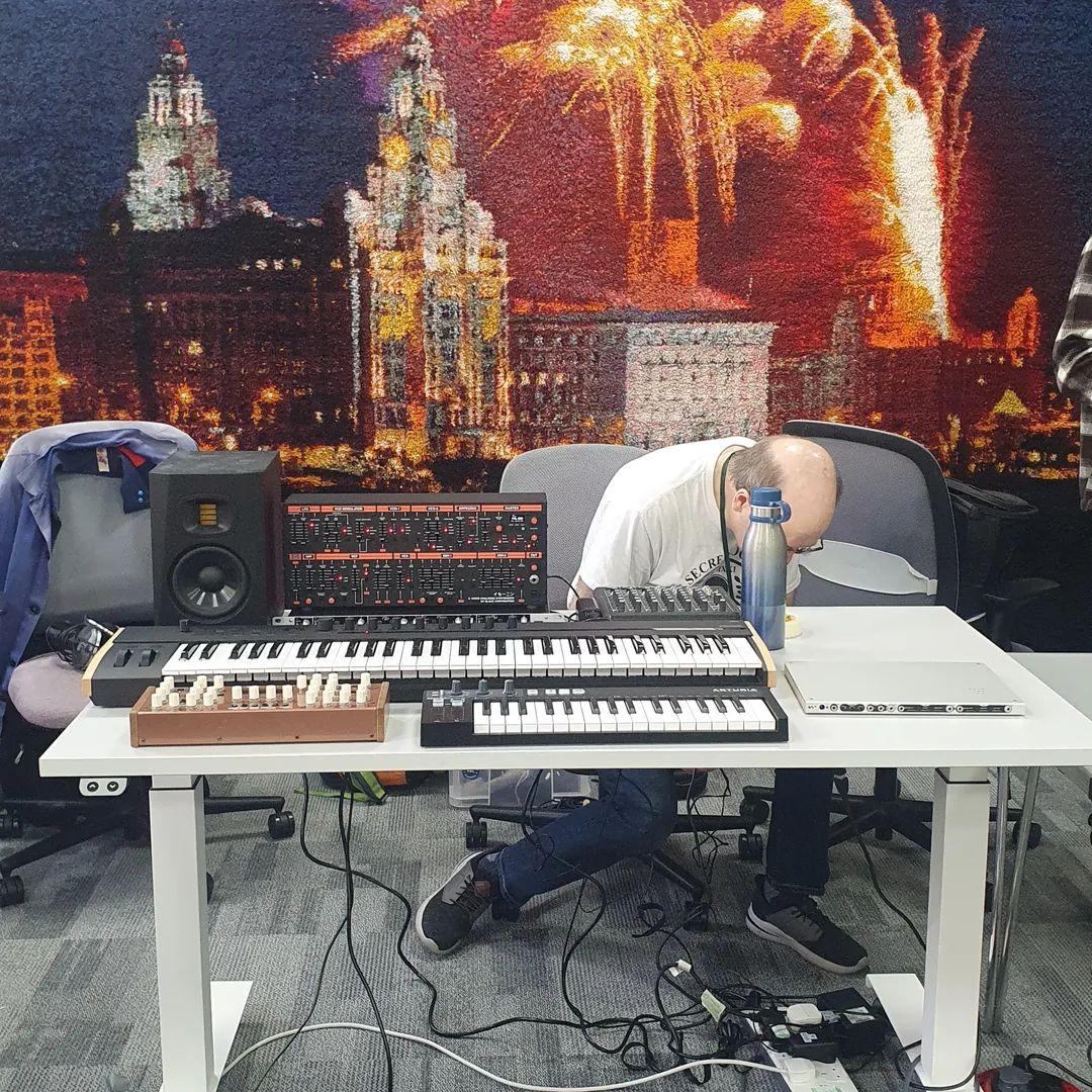 Mike setting up synths on the DoES Liverpool table, in front of his Very Large Rug
