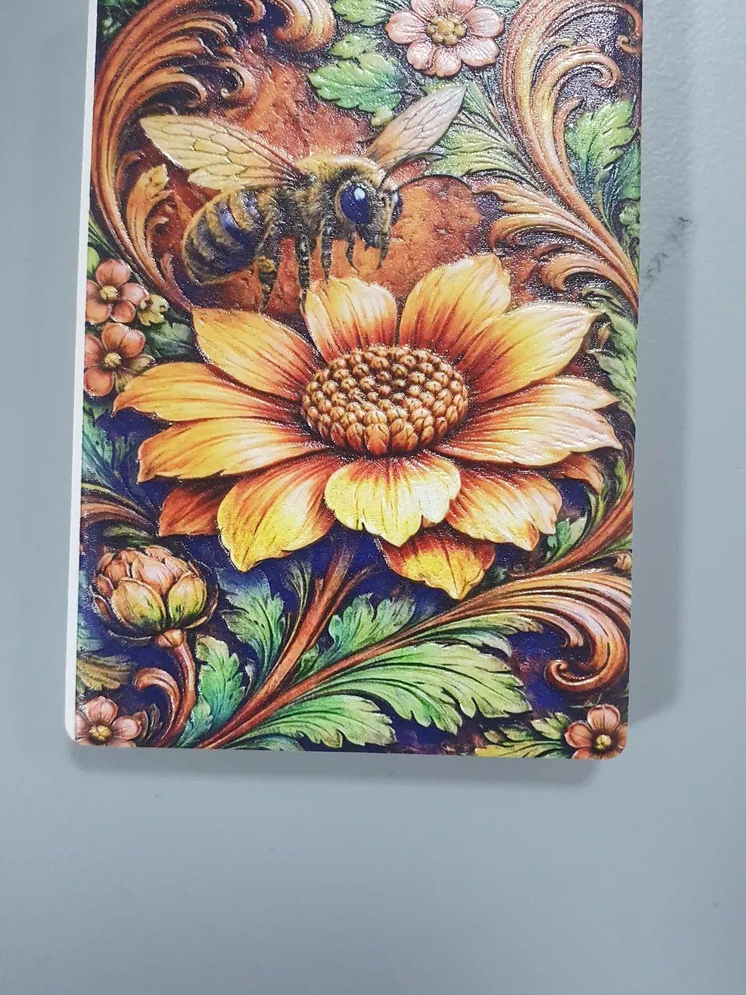 A fridge magnet of a sunflower and foliage, with 3d texture