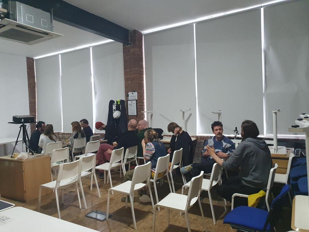 Rows of white chairs, with some people sitting 