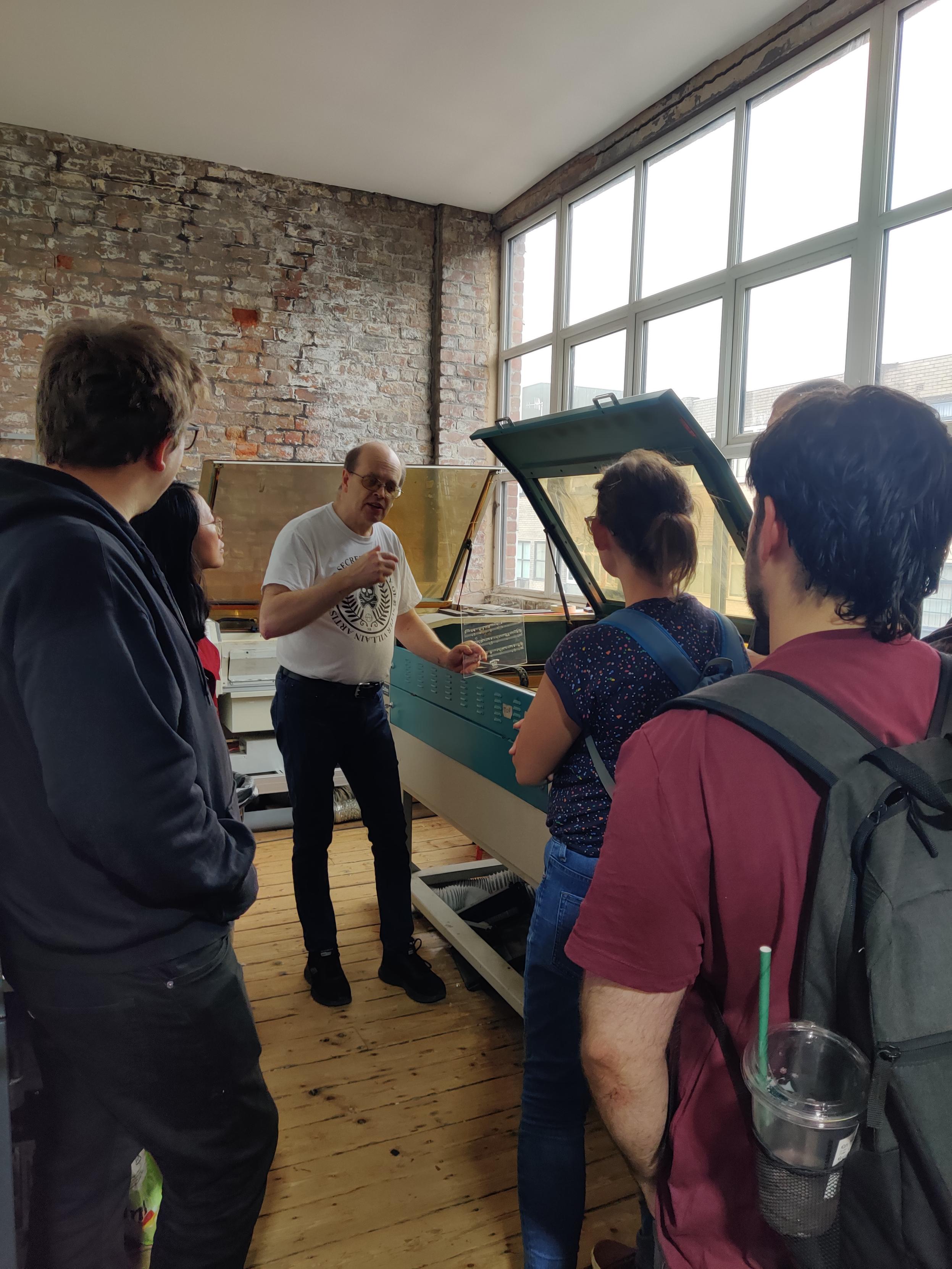 Mike showing one of our laser cutters to some afternoon visitors 