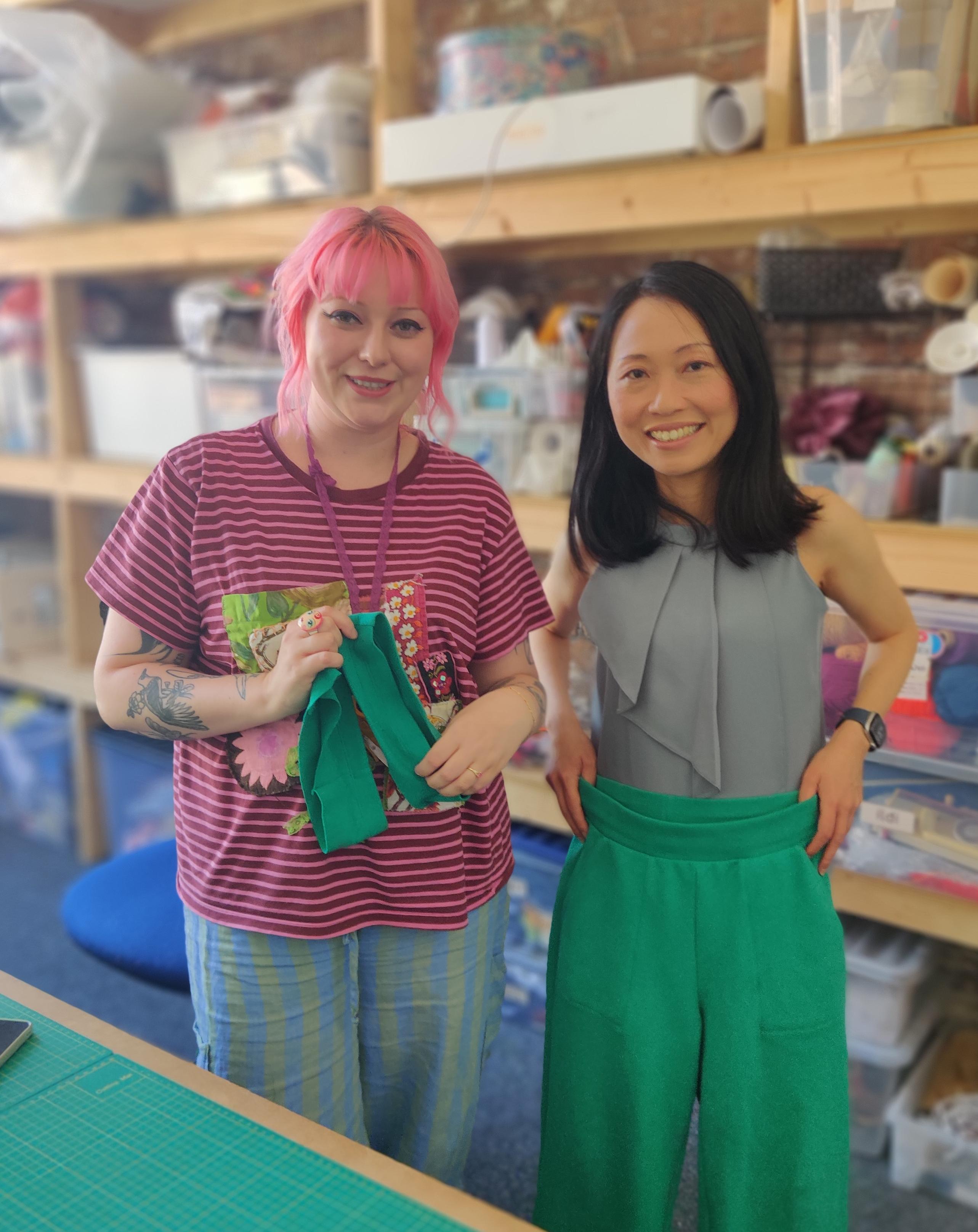 Clarice holding her green trousers and Scarlett holding the cut off hems