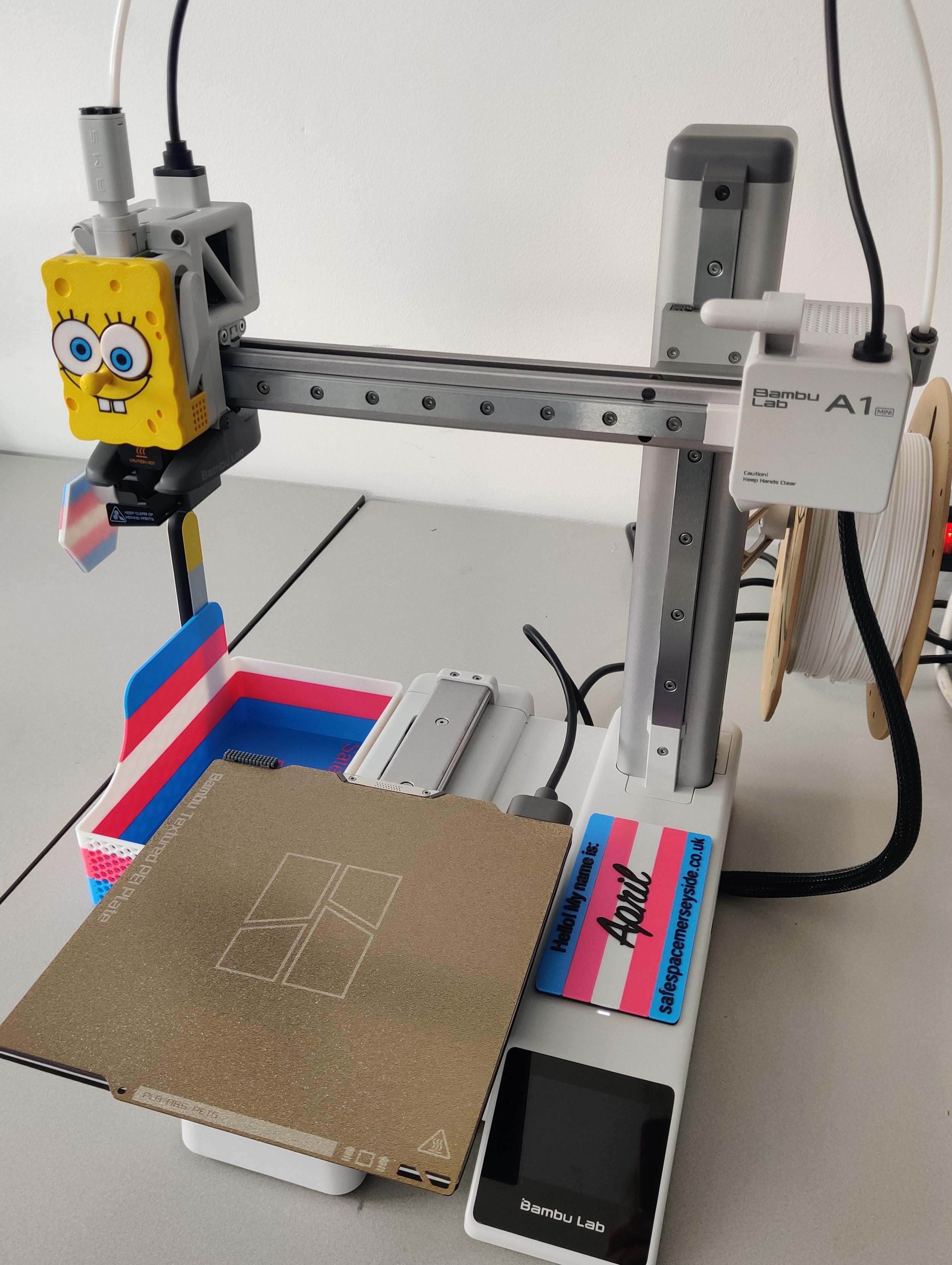 A BambuLab A1 Mini printer, with Sponge Bob hot end cover and name label