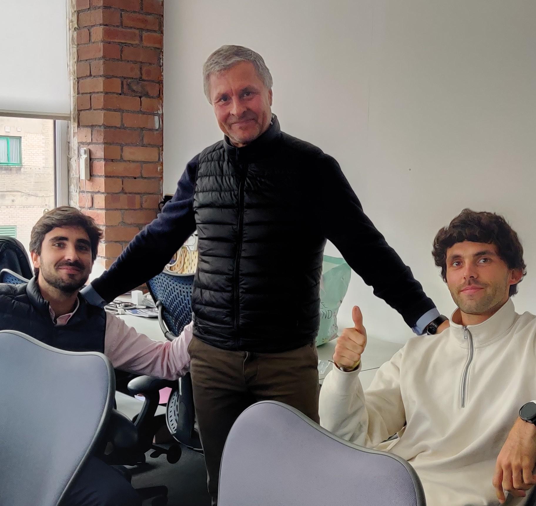 3 men, two sitting and one standing, by desks in Room 29 at DoES Liverpool