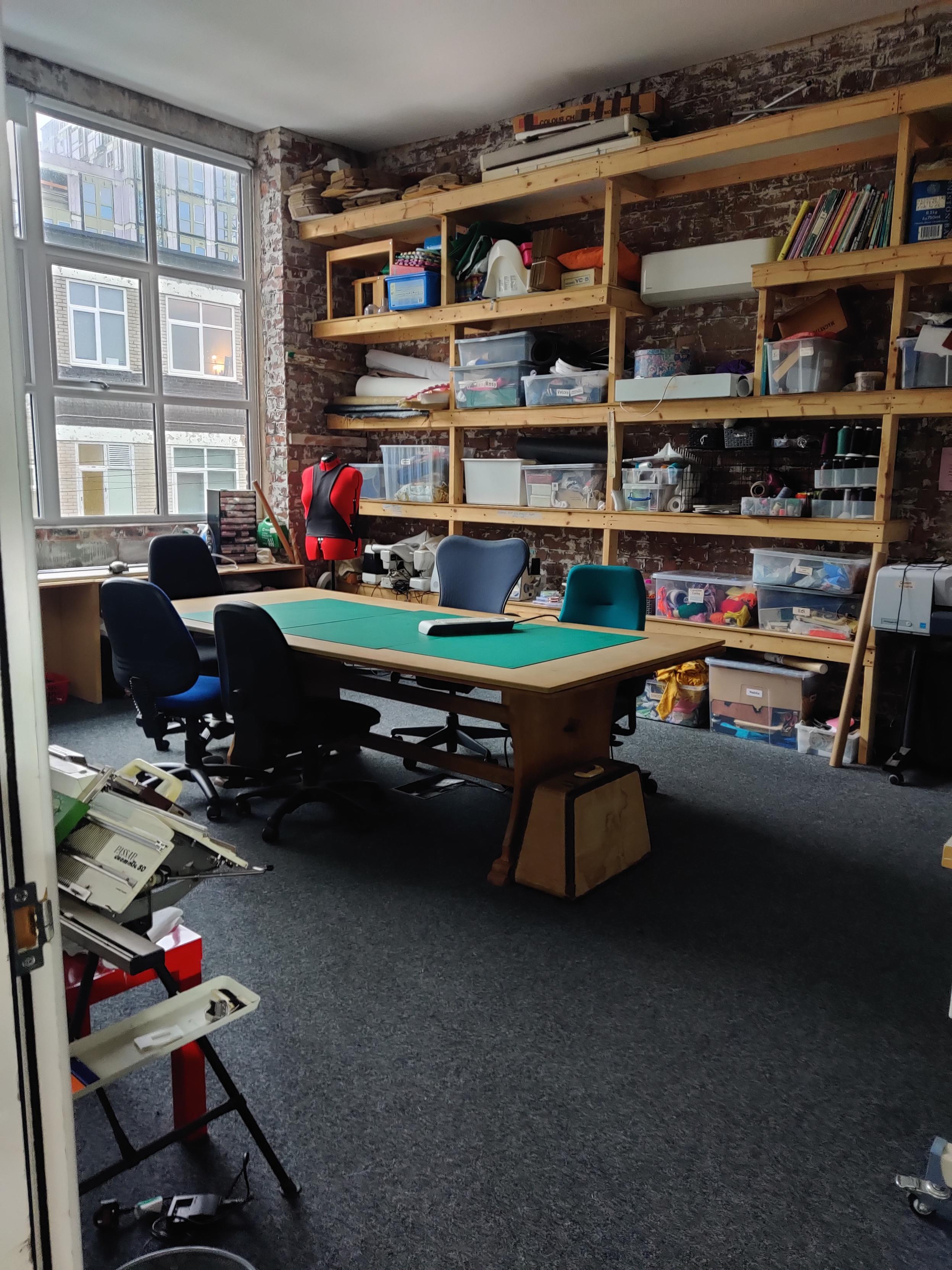 Our Fibre Arts room with cutting table and shelves 
