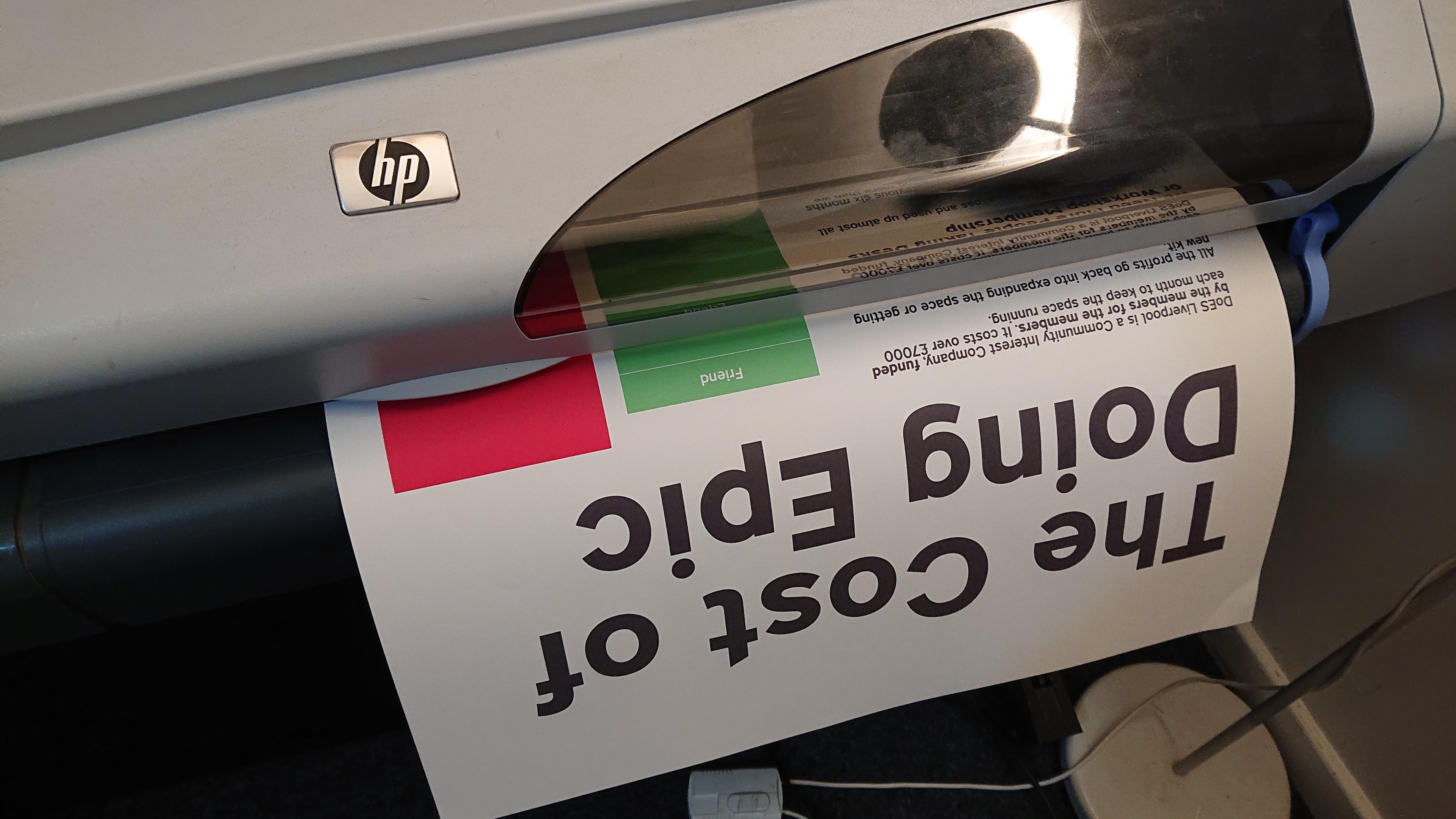 A close up of a very large printer, as it prints an A1 poster. The poster has a headline reading 