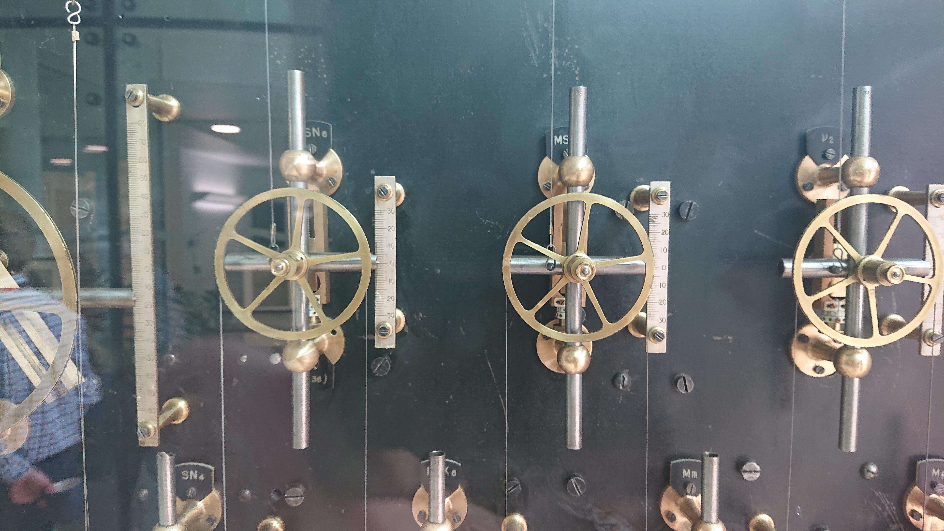 A closer shot of some of the brass pulleys and mechanisms of the machine. There's a wire running over each one, that wends its way around the whole machine, and they're all labelled with their particular 