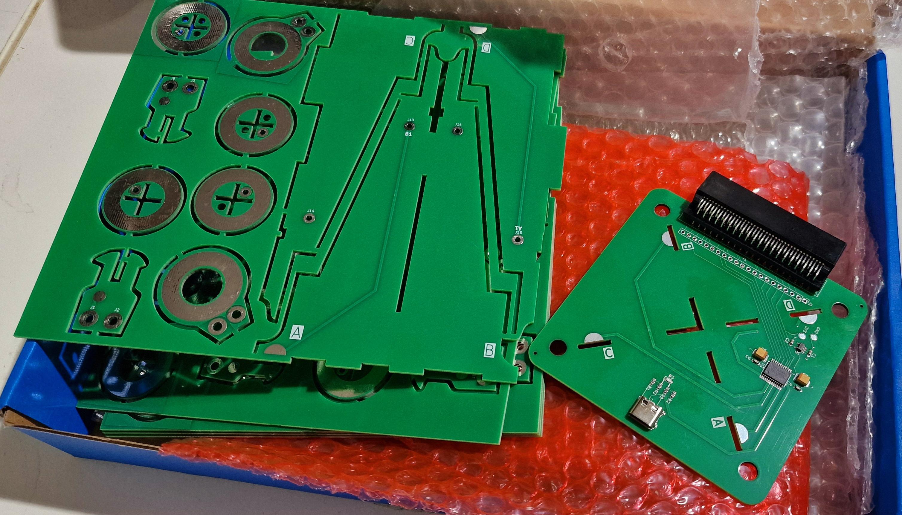 Two large green circuit boards, one populated with components, the other a complicated looking interlocking design. Those that aren't reading alt text will have to wait to find out it's a microbit controlled aeroplane game. Hopefully.