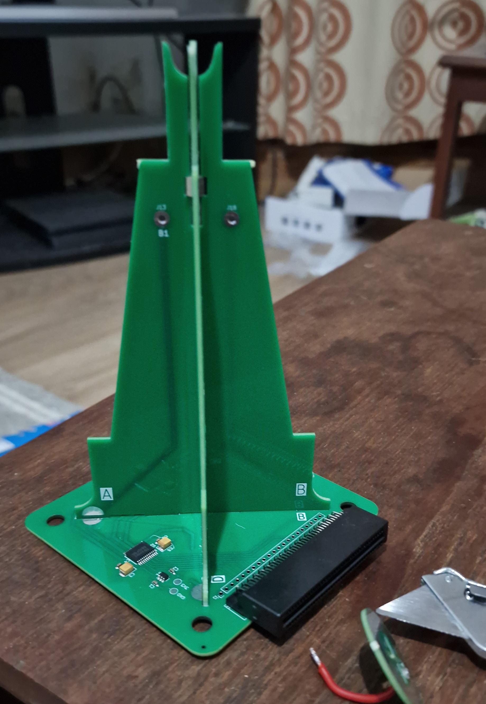 Green pcb tower on a square base. To the right is a microbit edge connector, to the left on the base a motor control circuit in smd components. Eventually the microbit will receive bluetooth signals to control planes connected to the top of the tower.