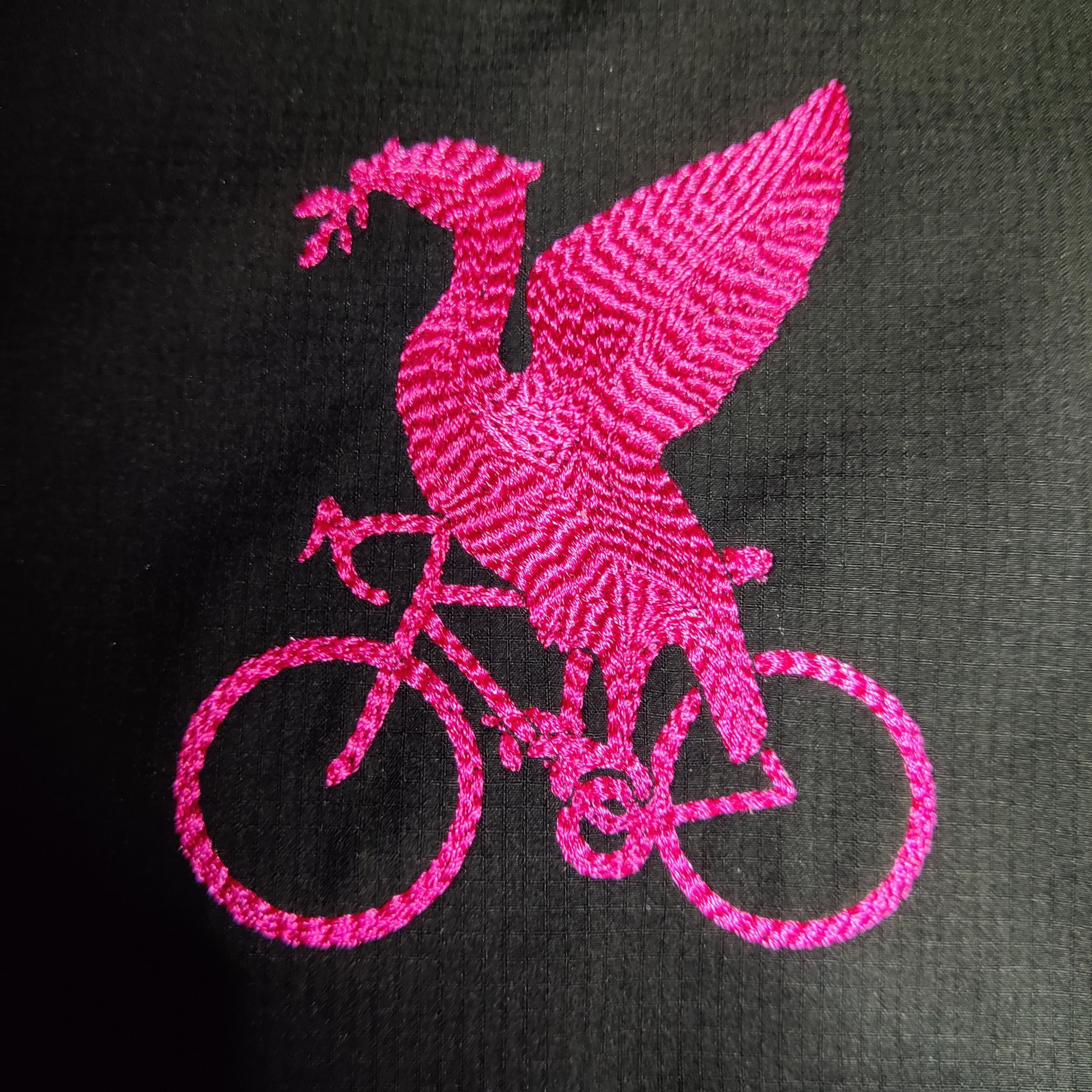 Ridged-effect bright pink embroidery of a Liver Bird on a bike - on a black waterproof