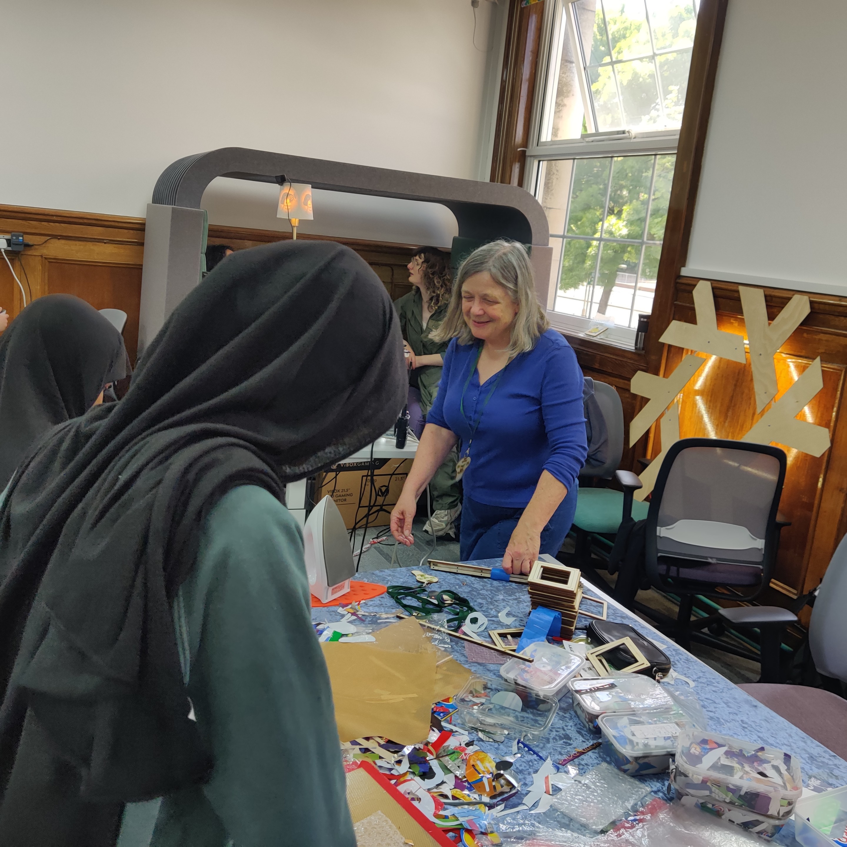 Me showing two young visitors how to put together soft plastic pictures and frames.