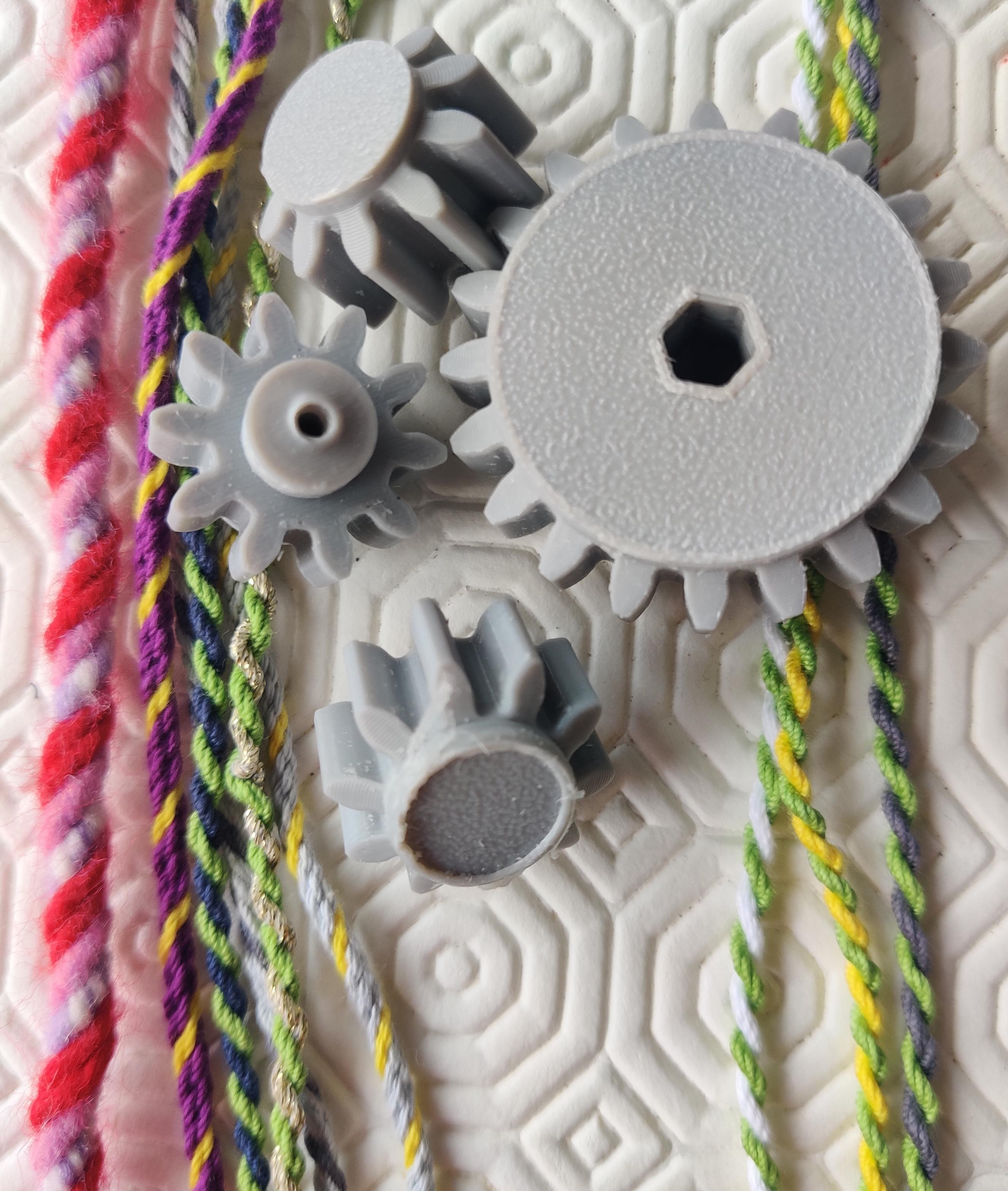 Grey cogs, some damaged, and twisted cords, on a white attended background.