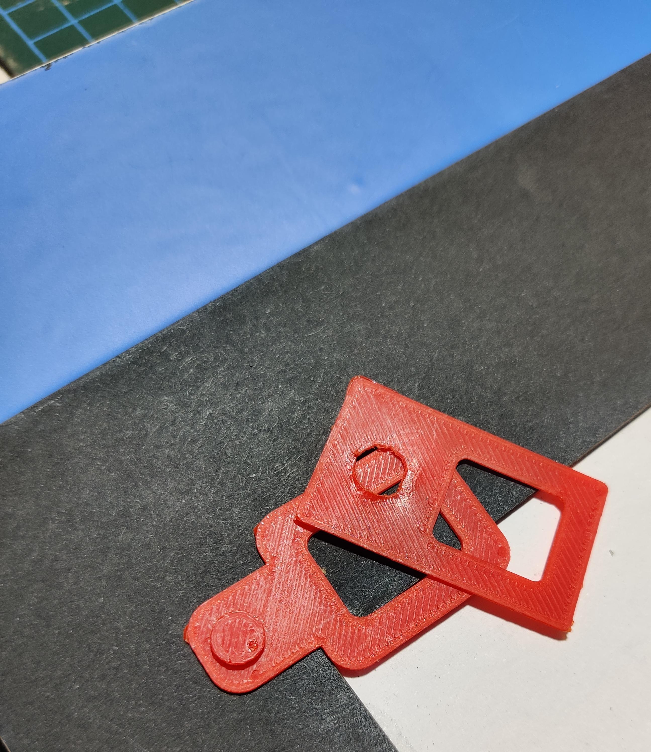 A (roughly) 3d printed registration pin and tab on a backing made from mount board and vinyl tape