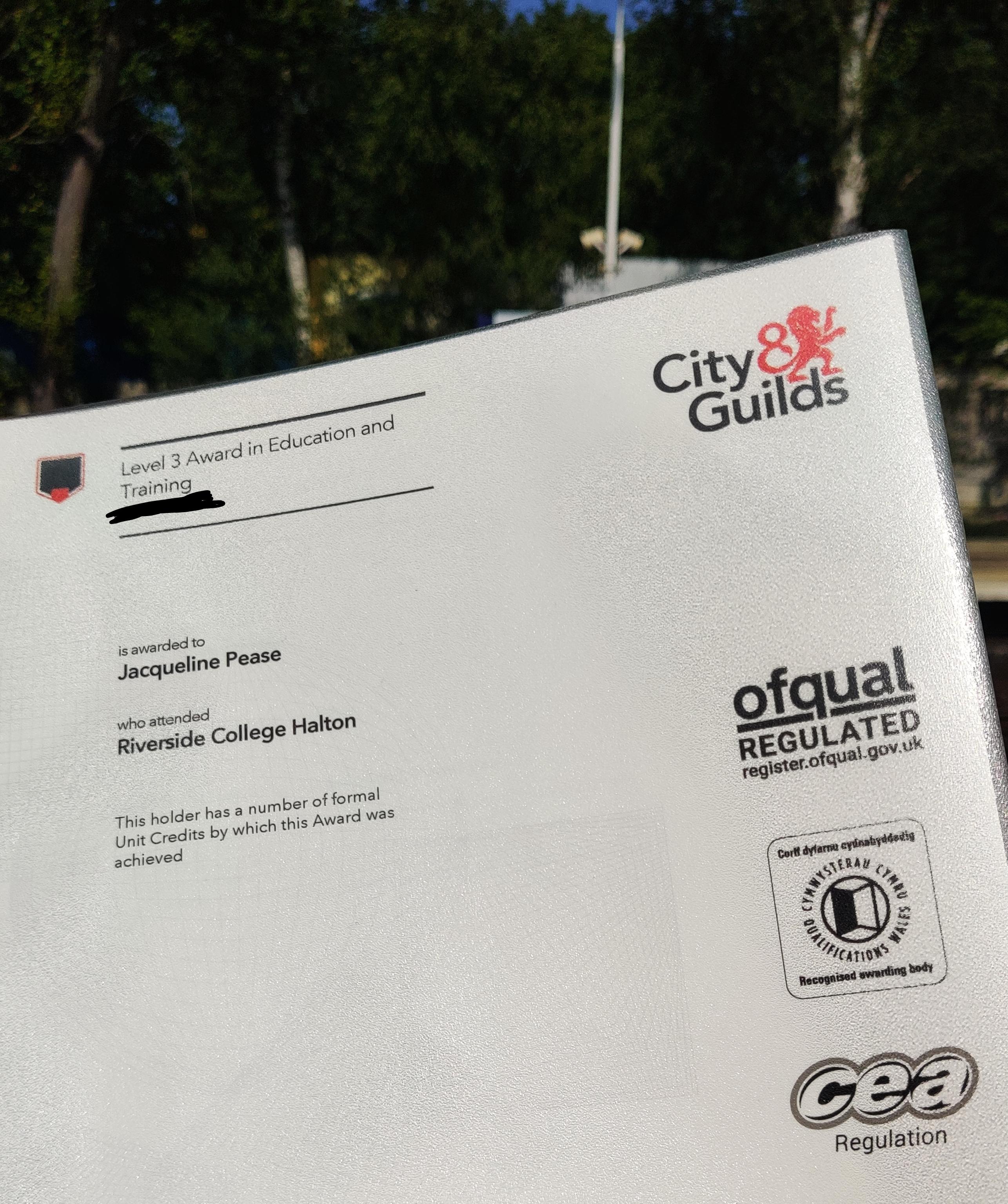 A photo of a City and Guilds Level 3 Award in Education and Training, with Widnes station in the background.