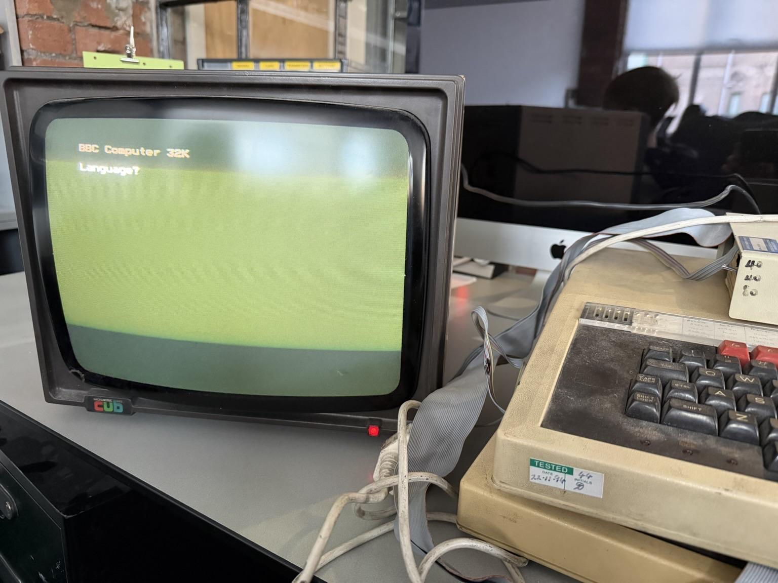 An old RGB CRT computer display shows a greenish screen with the text 